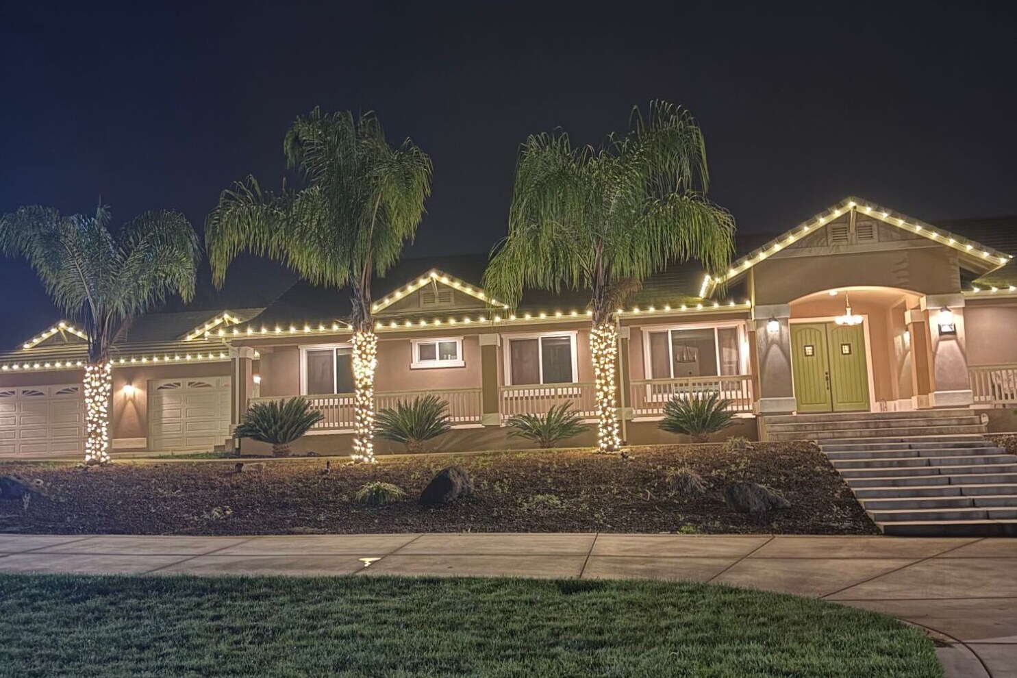 Christmas light installation in Carmichael, CA: ranch home warm white roofline palm wraps front